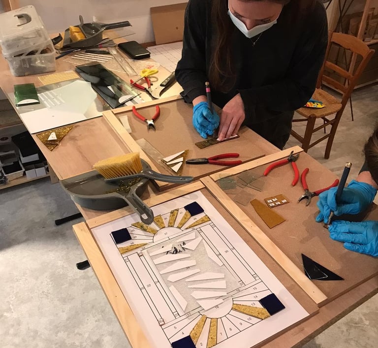 Initiation au vitrail : élève réalisant une coupe de verre sur-mesure.