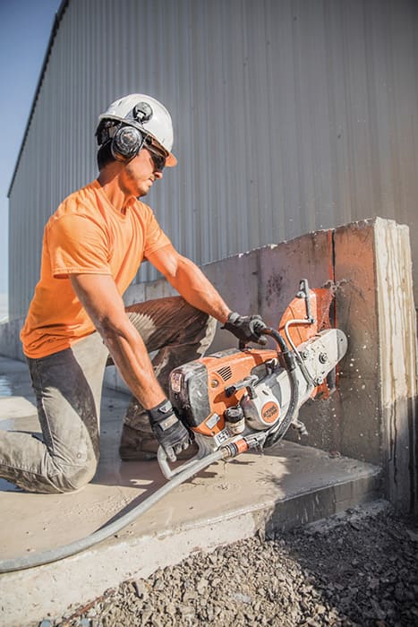 a man in a helmet is cutting a concrete block with ts800 saw