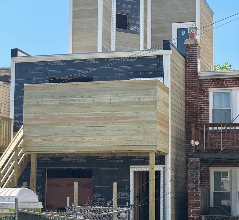 a house with a large wooden deck and a fenced in area