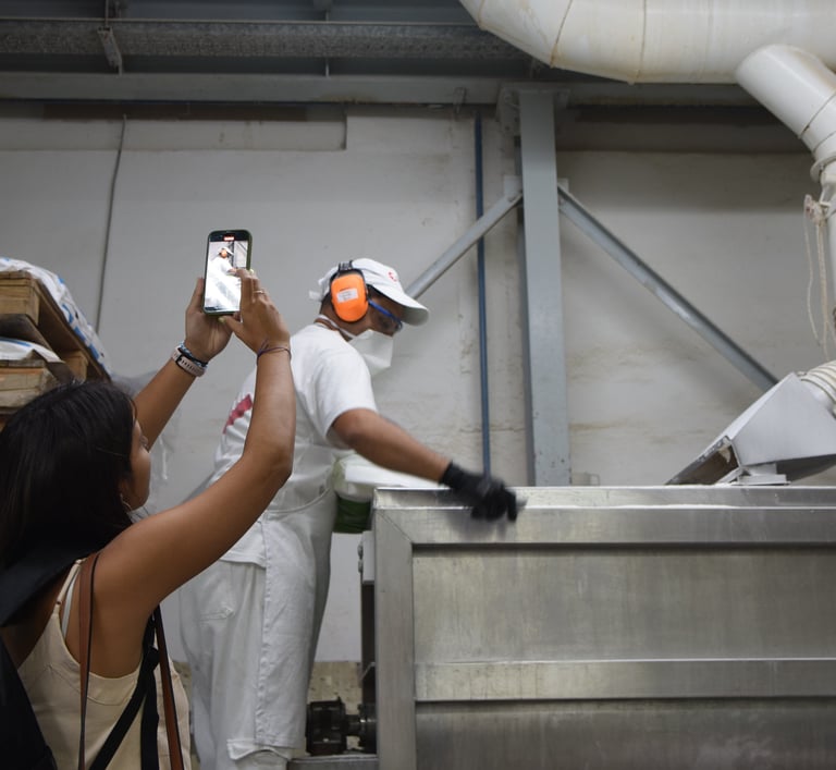 una joven filmando a un operario en una fábrica
