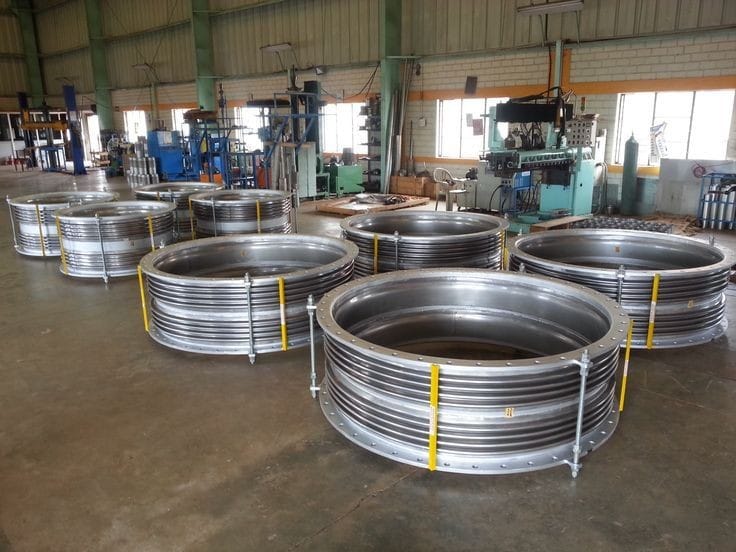 a large group of metal pipes and pipes in a warehouse