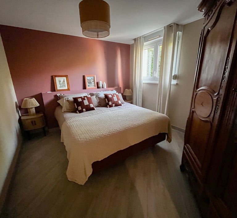 a bedroom with a bed and a wooden cabinet