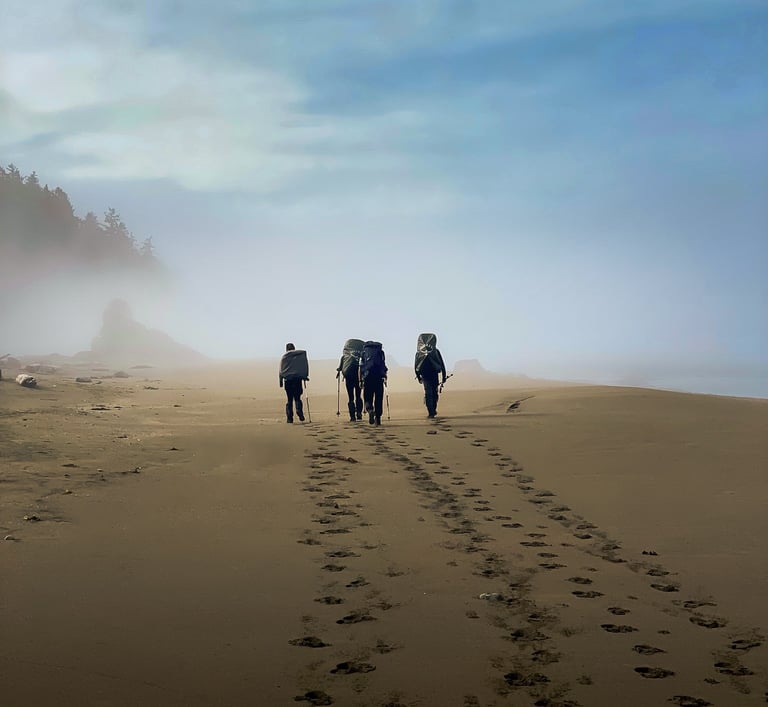 Group of backpackers hiking along a beach, showcasing adventure travel, exploration, and immersive