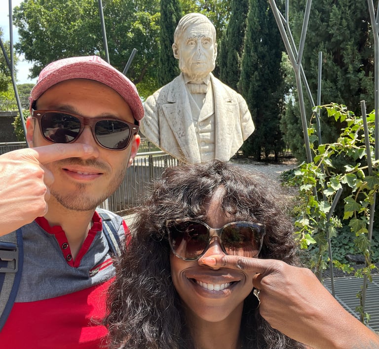 a man and woman posing for a picture in front of a noseless statue