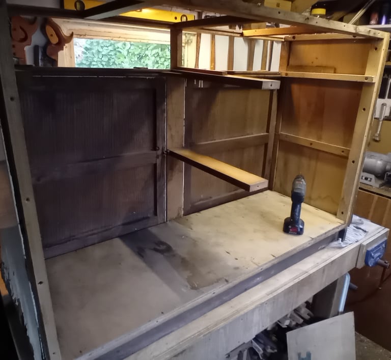 Rear view of the cupboard sitting on a workbench. It has no back panel or internal supports.