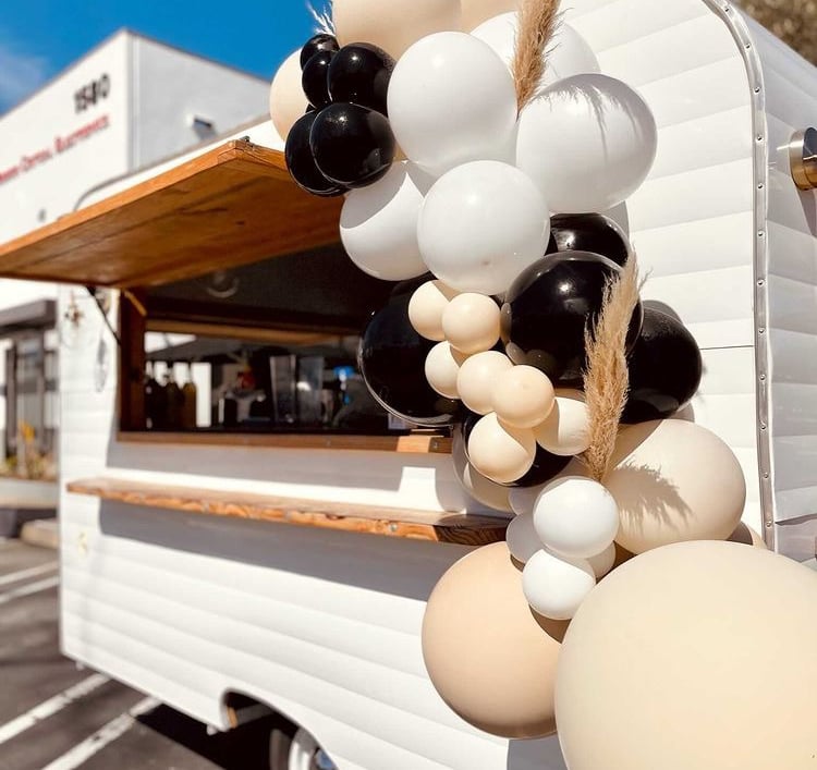 a food truck with balloons party planner