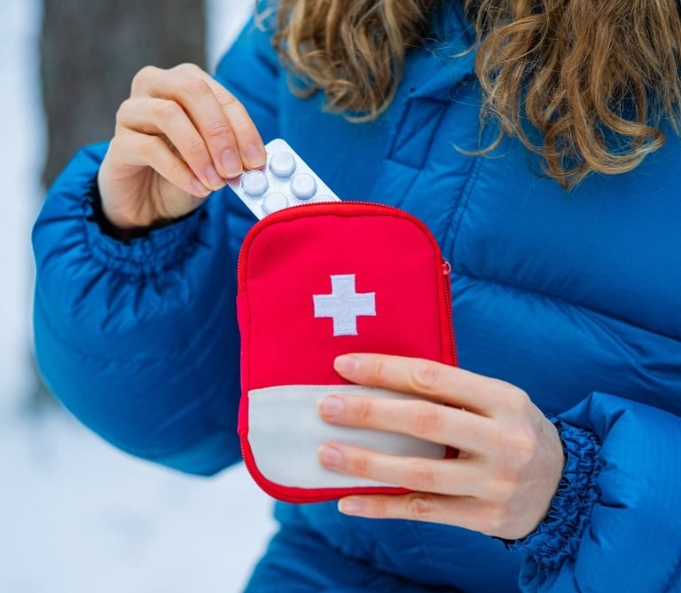 a woman in a blue jacket and a red cross - body bag