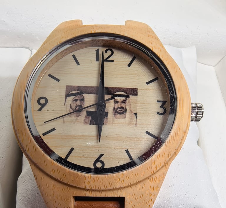 Custom wooden watch with a brown leather strap and engraved portrait of Arab leaders.