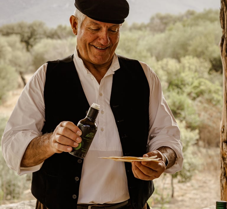 Man in traditional dress pouring olive oil on pane carasau, Sardinia