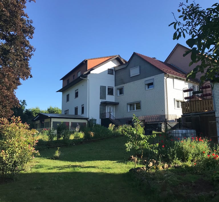 Links im Bild ist der Neubau, in der Mitte das Haupthaus, ganz rechts im Bild die Scheune.