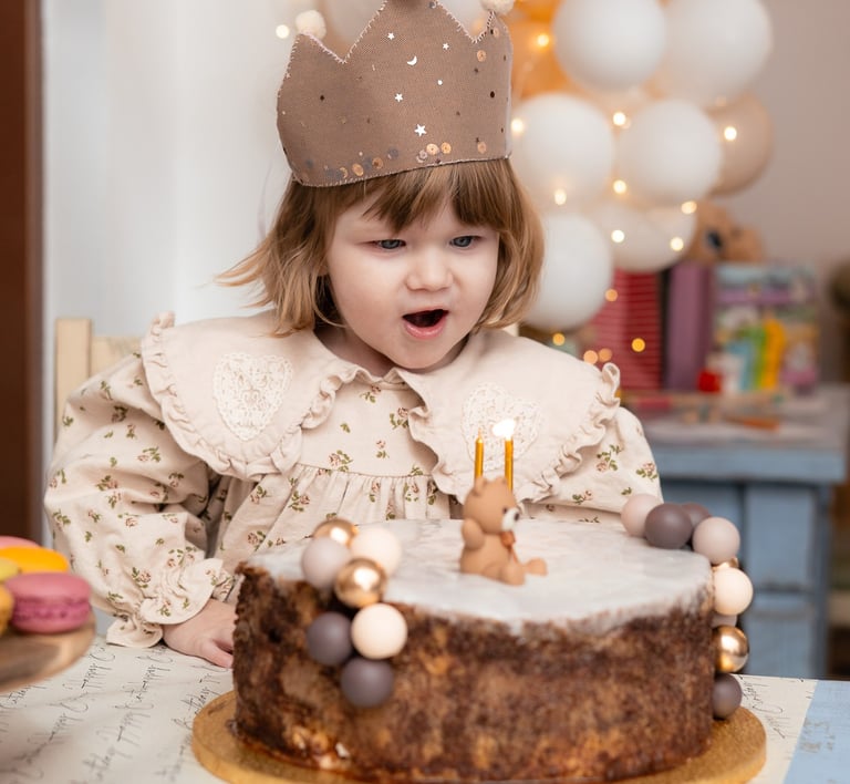 mala djevojčica koja puše svijeće na torti