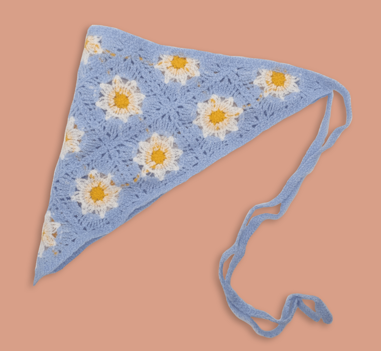 a blue crochet head scarf with flowers on it