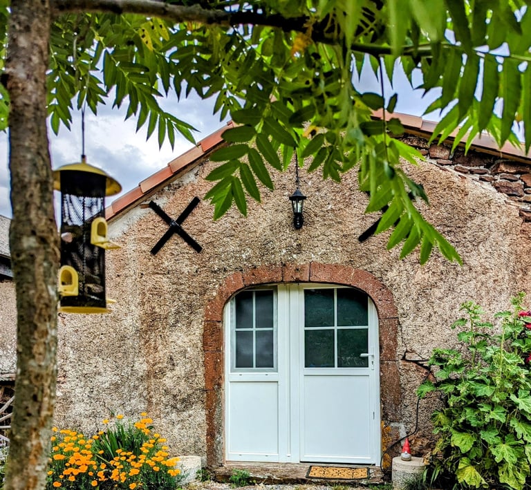 une mangeoire à oiseaux et la façade du Petit Logis