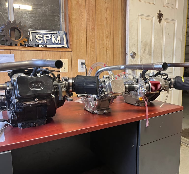 3 Go Kart race engines on display sitting on a desk.