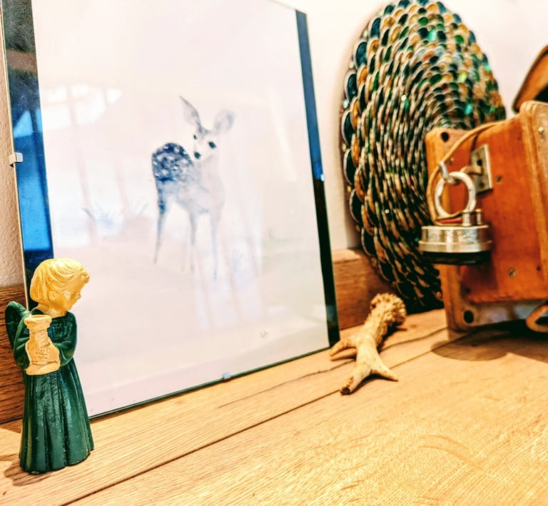 Dessin d'une biche, figurine d'un petit ange et bois de chevreuil