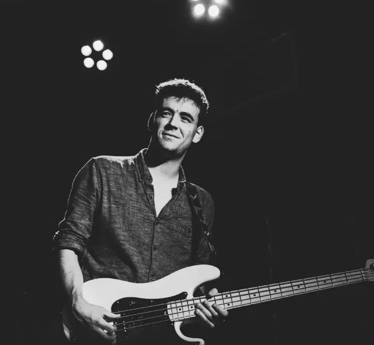 Mosaic's bass player performing a soulful blues-rock groove on stage