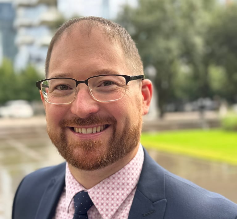 Dan Kyzer Guitar Headshot in blue suit with Dallas background. 
