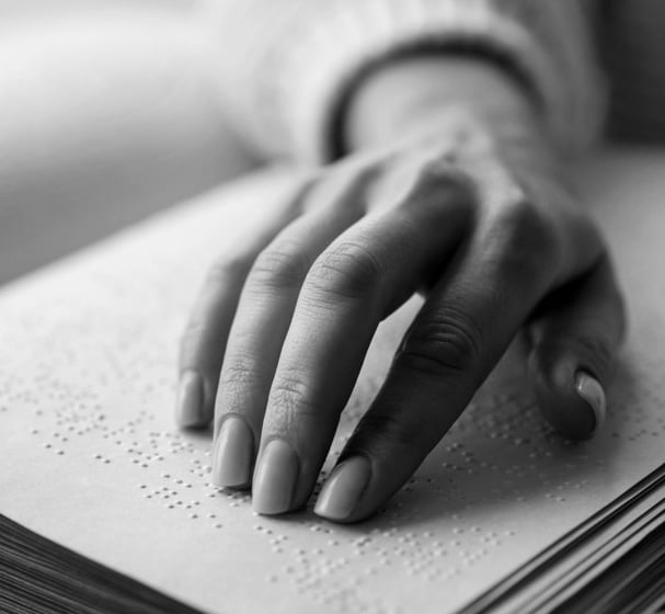 Niewidoma osoba czyta książkę w brajlu