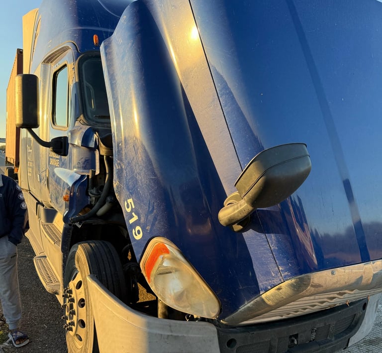 a semi truck with a large blue truck behind it