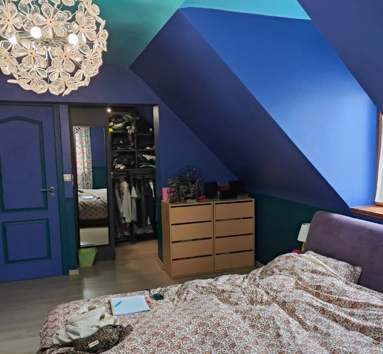 vue sur un dressing ouvert, commode en bois et murs bleus