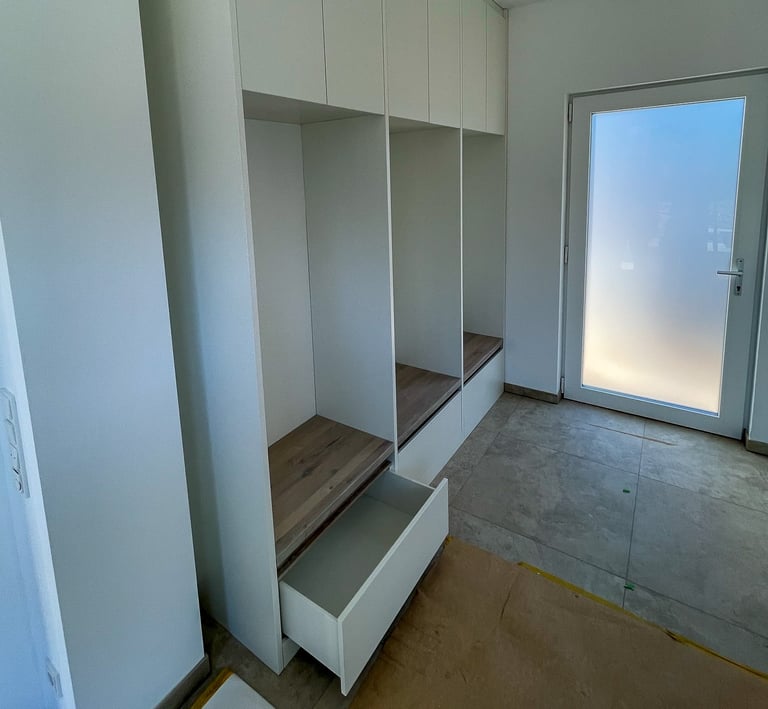 Maßgefertigte Garderobe mit integrierter Sitzbank und Schubladen für Schuhe von Tischlerei Gintner