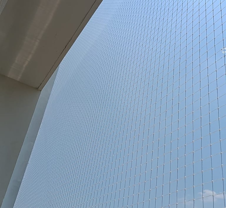 Close-up of a freshly installed balcony safety net securing a high-rise apartment.