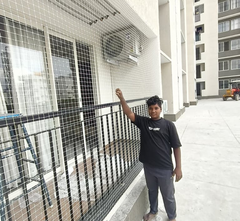 Close-up of a sturdy balcony safety net installed on a modern apartment in Electronic City.
