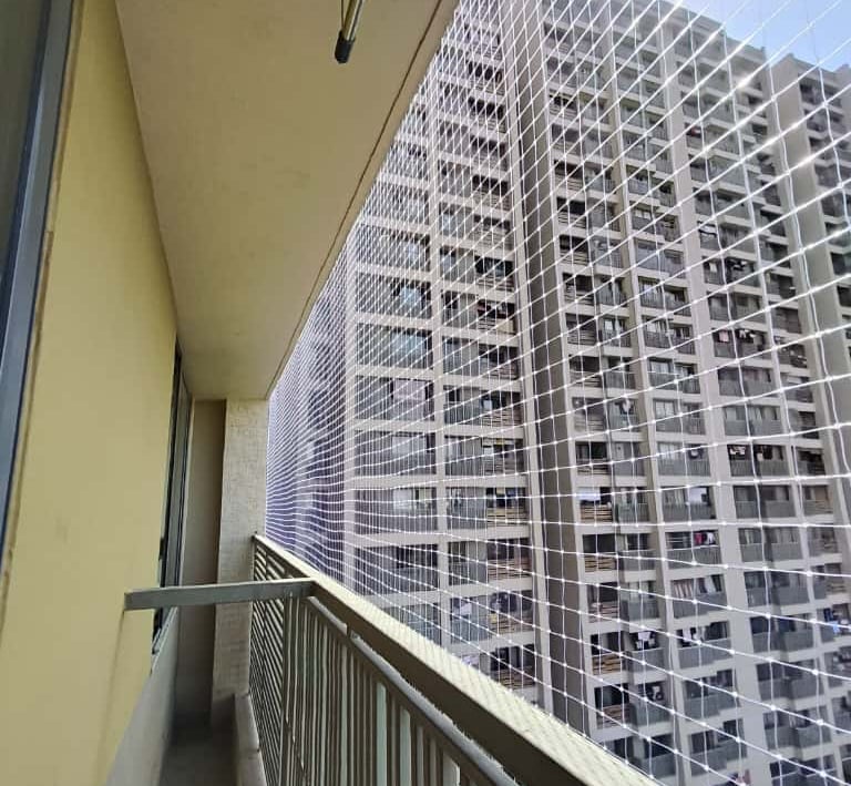 Installation process of pigeon nets on a window in a Bangalore apartment.