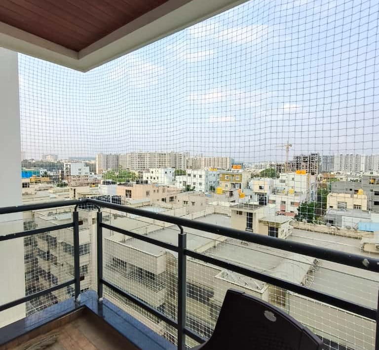 Side view of a balcony safety net installation showing secure anchoring points and neat finishing in