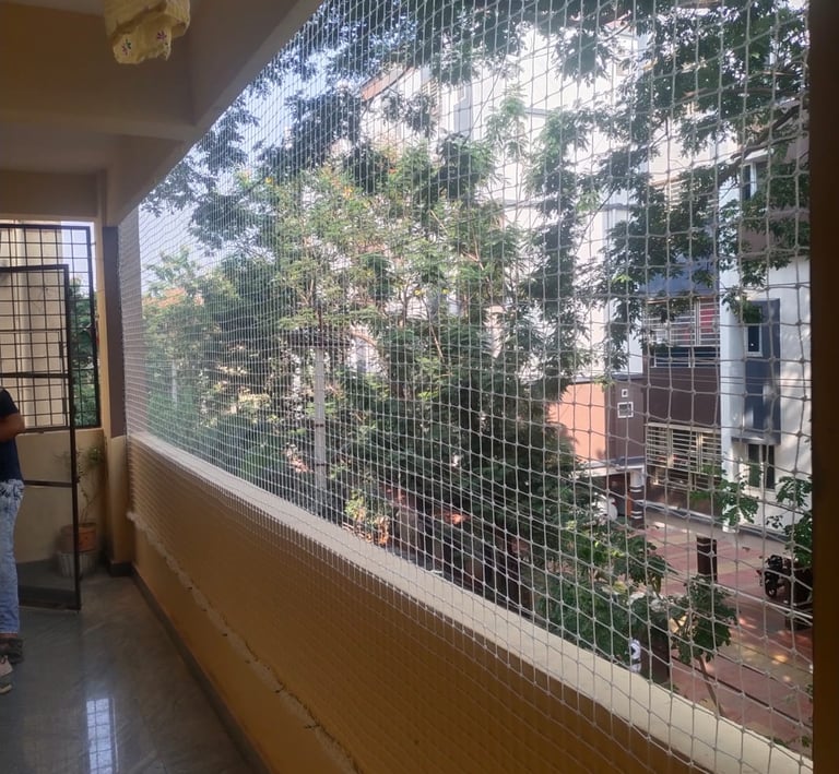 A securely netted balcony with sunlight filtering through, highlighting the netting’s strength and n