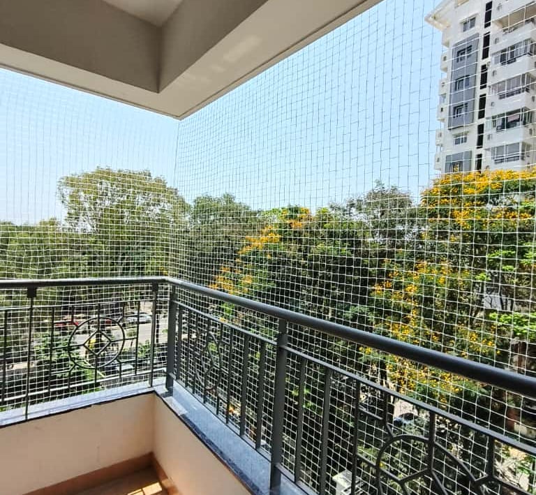 Close-up of a sturdy balcony safety net securely installed on a high-rise apartment.