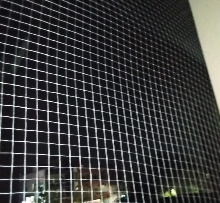 Close-up of a securely installed balcony safety net with a busy urban backdrop in Choolaimedu, Chenn