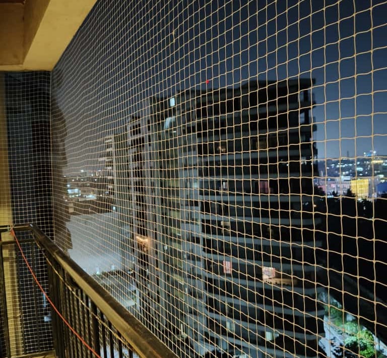 Close-up of a neatly installed pigeon net on a balcony in Electronic City, Bangalore.