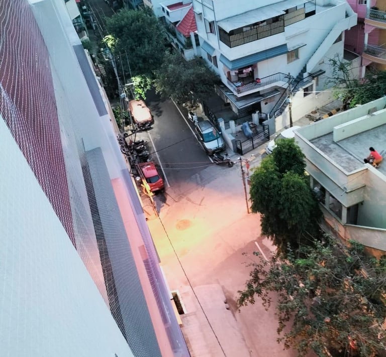 Technician from Arjilli Enterprises carefully fitting a safety net on an Egmore apartment duct.