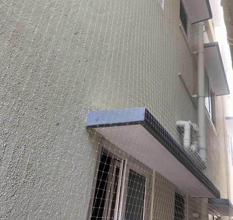 Close-up of a sturdy safety net securely installed over an apartment duct area in Egmore.
