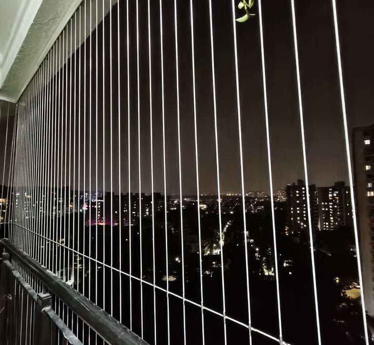 Evening shot of a balcony with gentle lighting, showcasing the protective bird net that keeps pigeon