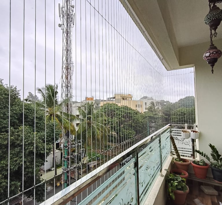 Close-up of a sleek invisible grill seamlessly installed on a Nungambakkam balcony, blending safety 