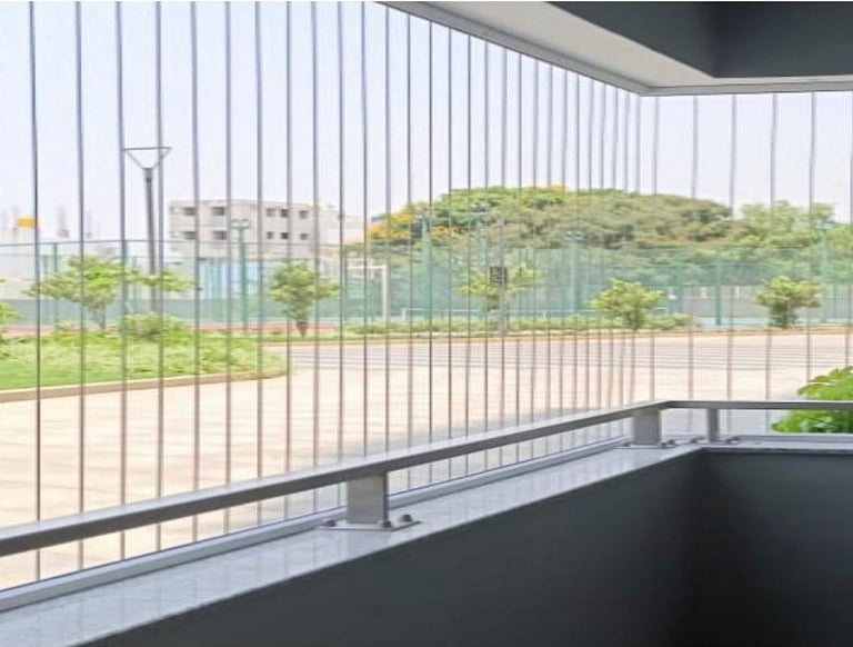 Close-up of a sleek invisible grill installed on a Kodampakkam balcony, blending seamlessly with the