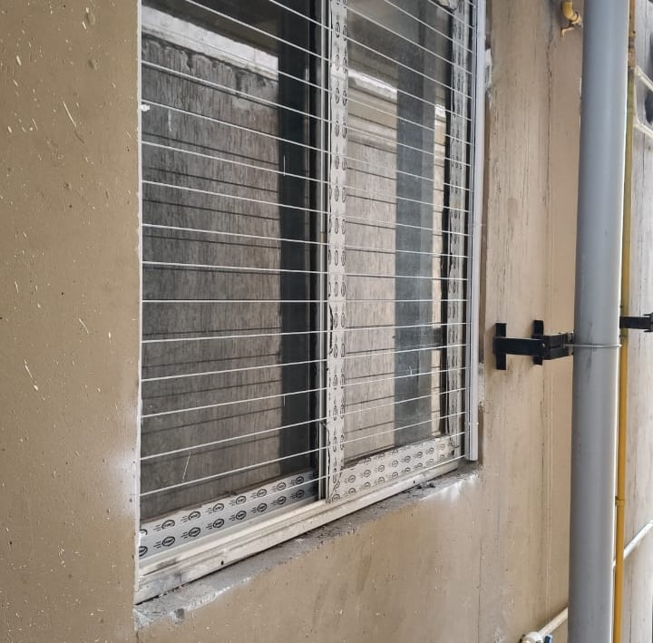 Evening photo capturing the soft glow through an invisible grill on a Mylapore window.