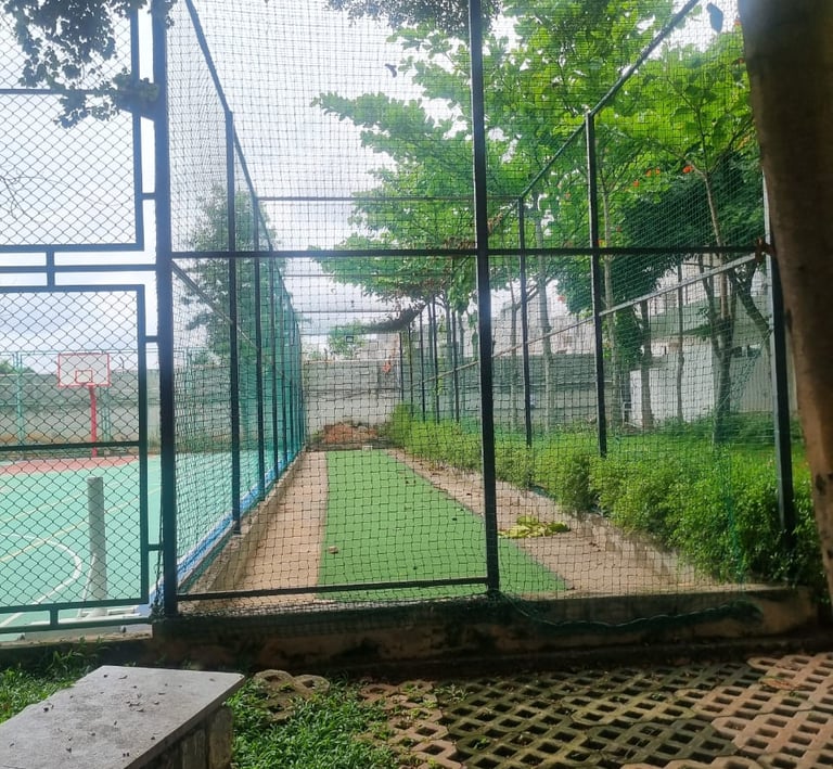 Hands tying knots on durable netting material, showcasing the craftsmanship behind each installation