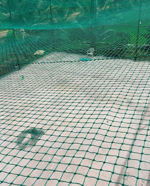 A football practice net anchored sturdily on a terrace with surrounding city view.