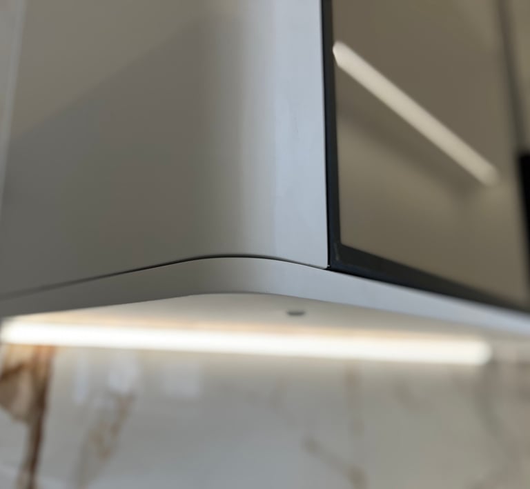 Modern kitchen cabinet with rounded corners and integrated LED under-cabinet lighting.