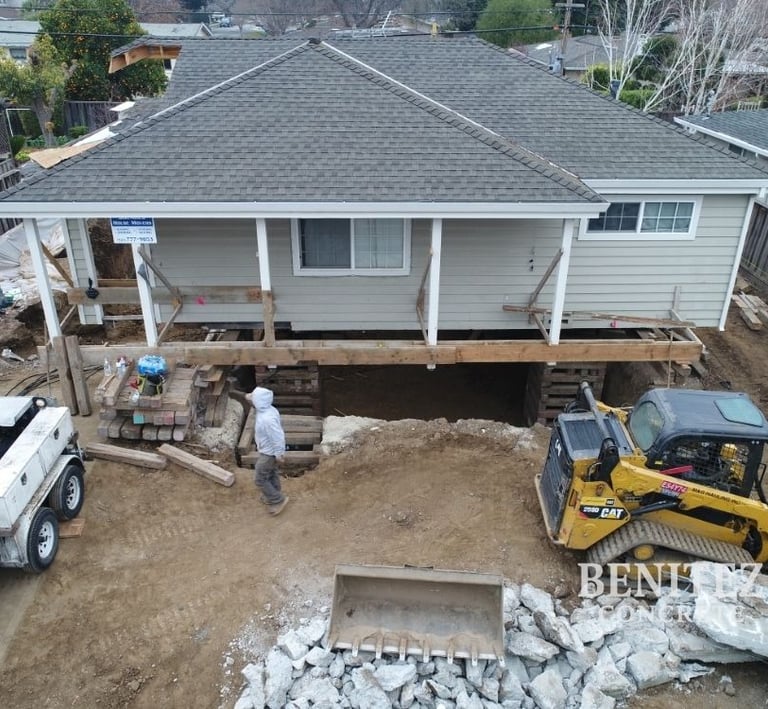 Crew raising house and pouring new basement foundation