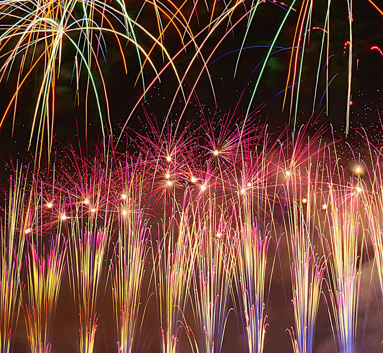 a large group of people watching fireworks in a field