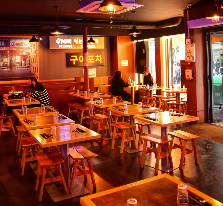 a restaurant with tables and chairs and people sitting at tables