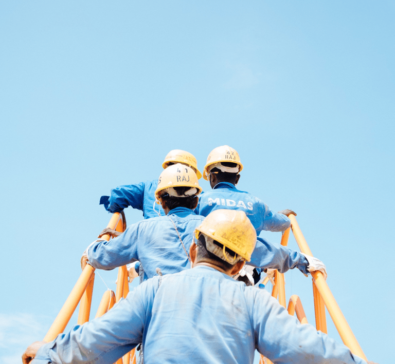 two men in blue workwears and helmets on a ladder ladder