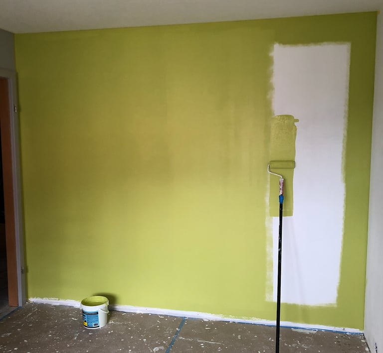 a room with a green wall and a paint roller