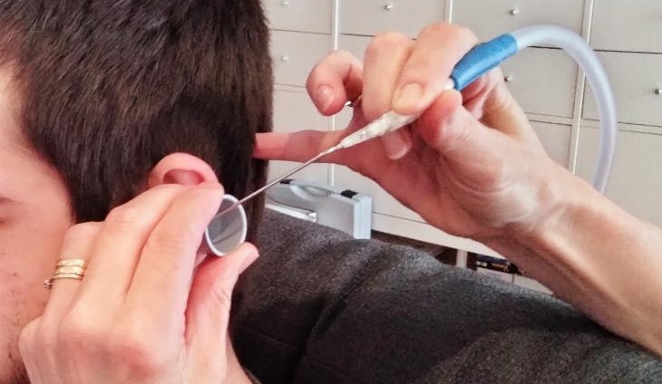man having ear wax removal with microsuction