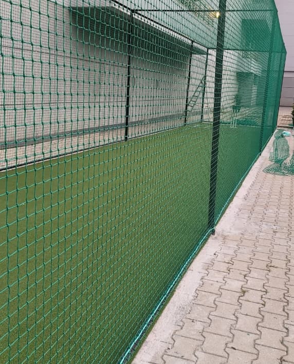 Action shot of a football net catching a ball during a lively match at a local park.