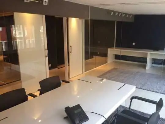 Mampara de oficina en vidrio laminado de espesor 5+5 mm. con puerta de melamina blanca, con luz cenital